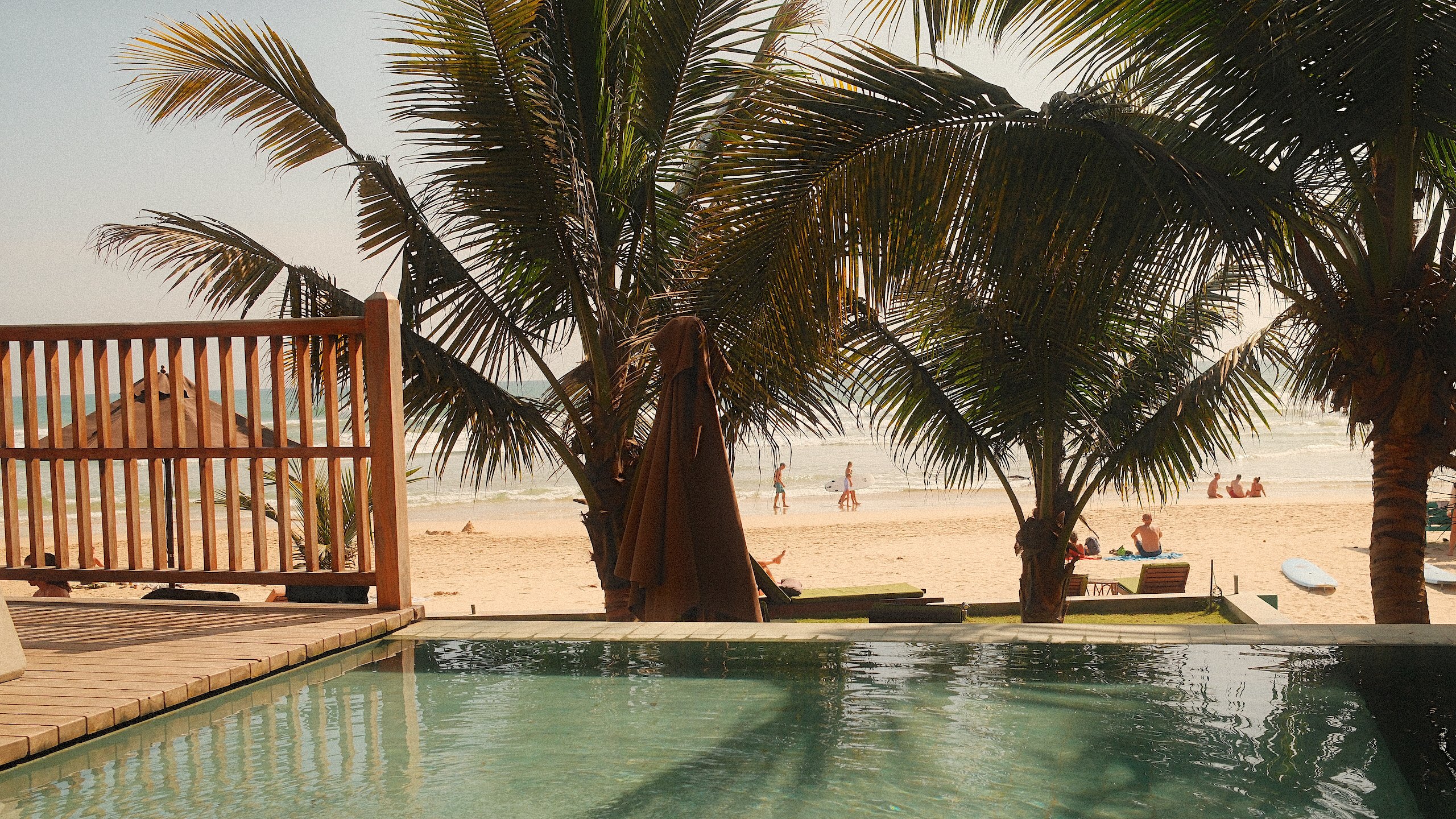 The pool at Coast 67, looking through coconut palms to Kabalana beach