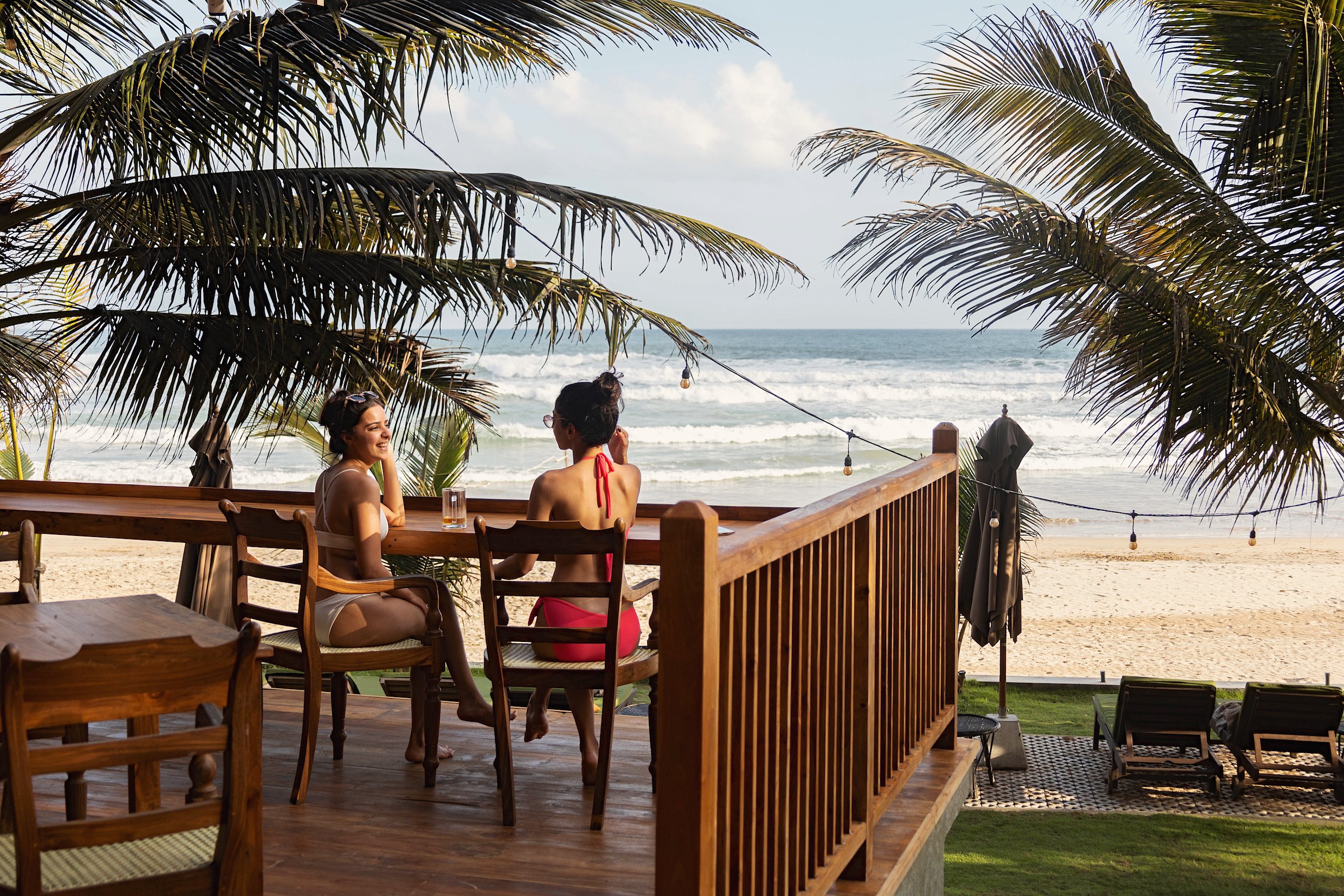 Two guests at a table on the deck above the beach